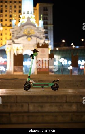 Mise au point sélective d'un scooter électrique stationné dans la rue la nuit Banque D'Images