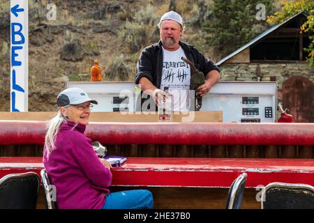 Junior, Longtime Mitchell; Oregon; résident; offre à un visiteur un cocktail pompé de son robinet de station-service extérieur; Mitchell; Oregon; États-Unis Banque D'Images