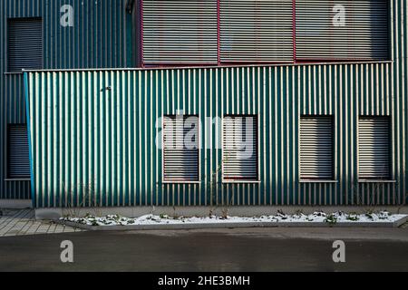 Un bâtiment scolaire vert à l'école Campus Rudolf Steiner Waldorf à Munich.Les fenêtres de l'ard se ferment avec des stores métalliques. Banque D'Images