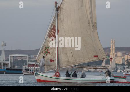 Un bateau Felucca avec des voiles patchées dans le Nil près de la ville d'Assouan en Egypte. Banque D'Images