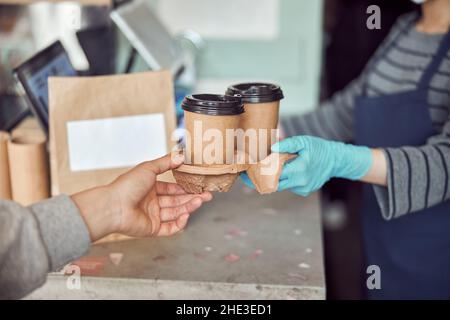Le personnel du café sert des plats à emporter à l'intérieur du client Banque D'Images
