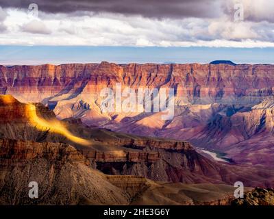 Grand Canyon avec le fleuve Colorado à distance nuages blancs au-dessus et des taches de lumière du soleil vus du parc national du Grand Canyon du plateau nord du cap Royal Banque D'Images