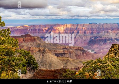 Grand Canyon avec le fleuve Colorado à distance nuages blancs au-dessus et des taches de lumière du soleil vus du parc national du Grand Canyon du plateau nord du cap Royal Banque D'Images