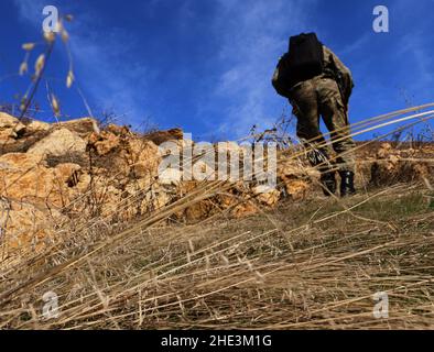 Soldat turc, le fond avec son sac noir sur son dos. Le soldat turc est en opération et monte sur la colline. Banque D'Images