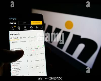 Personne tenant un téléphone portable avec le site de la société autrichienne bwin Interactive Entertainment AG à l'écran avec logo.Concentrez-vous sur le centre de l'écran du téléphone. Banque D'Images