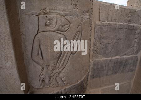 Une ancienne sculpture égyptienne d'un babouin jouant un instrument de musique au temple de Hathor dans le complexe du temple de Philae à Assouan, en Égypte. Banque D'Images