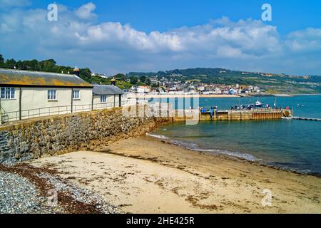 Royaume-Uni, Dorset, Lyme Regis, la plage Cobb, la pêche et Boatmans College, Harbour Wall avec ville et front de mer à distance Banque D'Images