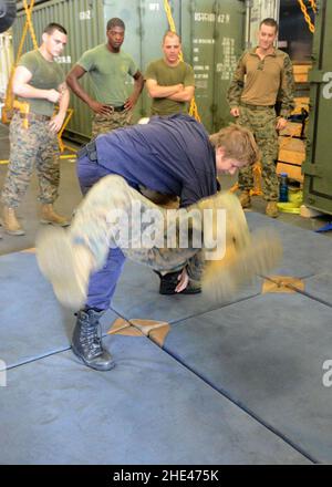 La Marine royale des pays-Bas Petty Officer 1st classe Marielle van Dijk joue un jet judo sur le corps de Marine américain lance Cpl.Josh D. Mutchler pendant l'entraînement en arts martiaux mixtes à bord de la Marine royale des pays-Bas Banque D'Images