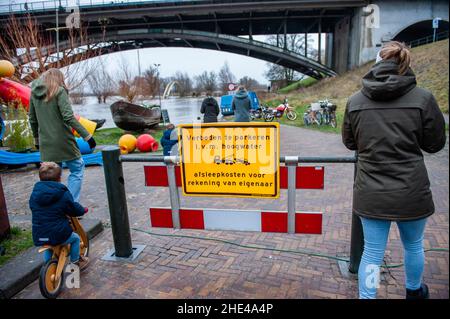 Nimègue, pays-Bas.08th janvier 2022.On voit des gens traverser le panneau qui se réchauffe au sujet du niveau d'eau élevé près du pont de Waal.l'eau dans les rivières est en hausse abrupte.Le matin, on s'attendait à une forte eau à la fois dans la Meuse et dans le Rhin.Même si les niveaux d'eau n'étaient pas si élevés qu'en janvier dernier, les gens se sont rassemblés autour des waalcades pour voir les niveaux d'eau élevés.Cette fois-ci, elle a atteint environ 13 mètres au-dessus de NAP ce week-end.La NAP est la base utilisée pour mesurer les niveaux d'eau élevés ou bas.(Photo par Ana Fernandez/SOPA Images/Sipa USA) Credit: SIPA USA/Alay Live News Banque D'Images