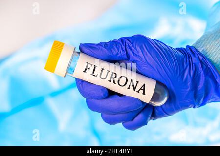 Nouvel échantillon de la maladie infectieuse de la grippe (grippe) et de Corona (Covid-19, Ncov) dans un tube de laboratoire dans la main du scientifique dans un gant médical bleu Banque D'Images