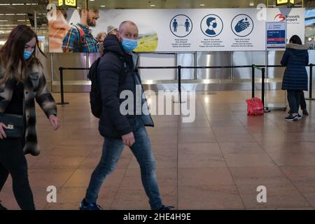 Zaventem, Belgique.8th janvier 2022.Les gens marchent devant un panneau rappelant aux gens les mesures contre le COVID-19 à l'aéroport de Bruxelles à Zaventem, en Belgique, le 8 janvier 2022.Selon l'institut de santé belge Sciensano, la Belgique a récemment enregistré une augmentation du nombre de cas de COVID-19, avec une moyenne quotidienne de 15 996 au cours de la période allant du 29 décembre 2021 au 4 janvier 2022.Credit: Zhang Cheng/Xinhua/Alay Live News Banque D'Images