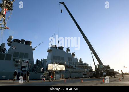 STATION NAVALE DE ROTA, Espagne (janv6, 2022) les Seabés affectés au bataillon de construction mobile navale (NMCB) 1 effectuent une opération de levage par grue pour soutenir le destroyer de missiles guidés de la classe Arleigh Burke USS Arleigh Burke (DDG 51), le 6 janvier 2022.La NMCB 1 est déployée à l'avance pour exécuter la construction, l'aide humanitaire et la coopération en matière de sécurité du théâtre dans les zones d'opération de la Cinquième, Sixième et septième flotte des États-Unis.(É.-U.Photo de la marine par le spécialiste des communications de masse 1st classe Caine Storino) Banque D'Images