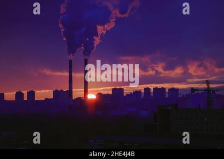 Cheminées fumeurs dans une ville au coucher du soleil pittoresque Banque D'Images