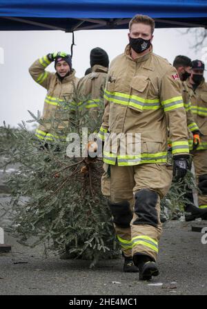 Richmond, Canada.8th janvier 2022.Un pompier transporte un arbre lors de l'événement annuel de coupe-bevins de Noël à Richmond, en Colombie-Britannique, au Canada, le 8 janvier 2022.Les pompiers se sont portés volontaires pour aider les résidents à recycler leurs arbres de Noël lors de l'événement annuel d'abattage des arbres.Credit: Liang Sen/Xinhua/Alay Live News Banque D'Images