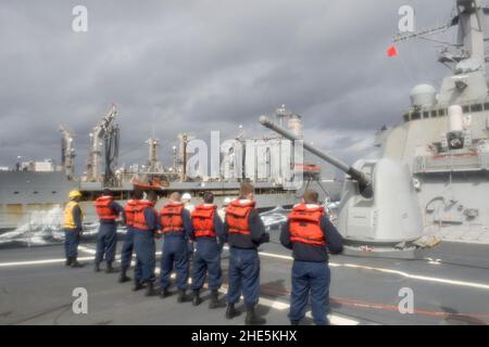 Des marins à bord de l'USS Arleigh Burke (DDG-51) ligne de téléphone et de distance pendant le réapprovisionnement en cours avec l'USNS Patuxent (T-AO-201) 131211 Banque D'Images