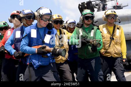 Les marins affectés au département de l'Air simulent la lutte contre un incendie lors d'un exercice d'incendie sur le pont de vol à bord du navire d'assaut amphibie USS Boxer (LHD 4).(26810273415). Banque D'Images