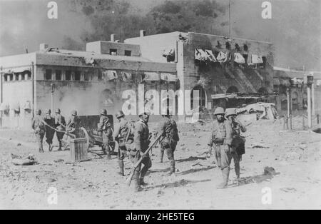 Seconde guerre sino-japonaise, 1937-1945.Les troupes de la Force navale d'atterrissage japonaise remorquèrent une pièce d'artillerie devant la gare nord de Shanghai déchirée par la guerre pendant la bataille de Shanghai, août-novembre 1937. Banque D'Images