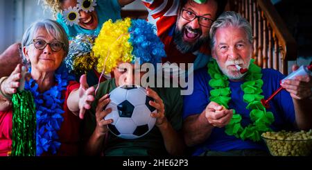 Groupe de fans de football à la maison profiter et exulter pour le succès de l'équipe - championnat du monde 2022 concept de télévision - famille regardant le football à la télévision à Banque D'Images