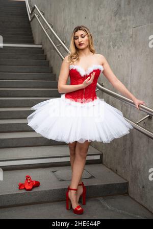 Ballerine portant des talons hauts et robe de noël posant à l'extérieur Banque D'Images