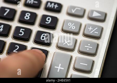 Appuyer avec le doigt sur le bouton calculatrice. Concept fiscal, concept comptable. Homme méconnaissable mains tenant et utilisant une calculatrice Banque D'Images