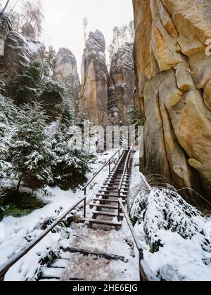 Échelle, escalier en bois et bannister en acier dans un labyrinthe rocheux de grès à la ville d'Adrspach, République tchèque.Visitez le parc en hiver Banque D'Images