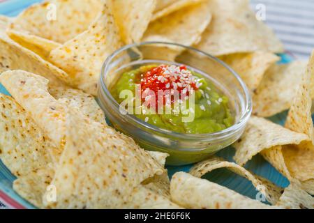 Nachos avec guacamole sur plateau bleu Banque D'Images