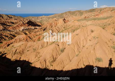 Ombre du photographe dans le canyon de conte de fées de Skazka.Lac Issyk-Kul en arrière-plan.Tosor, Kirghizistan Banque D'Images