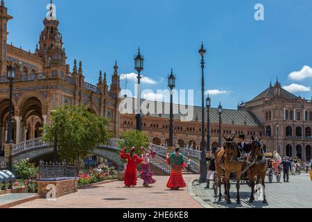 Les dames en costumes traditionnels de flamenco dansent à la Plaza de Espana, tandis que leur calèche attend des emmener à la Feria de Abril annuelle. Banque D'Images