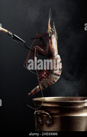 Les crevettes tigrées fraîches sont placées dans une vieille casserole d'eau chaude. Banque D'Images