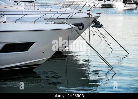 Yachts de luxe amarrés dans le port de mer au coucher du soleil.Parking maritime de bateaux à moteur modernes et d'eau bleue.Tranquillité, détente et vacances à la mode. Banque D'Images