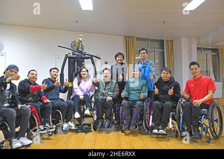 (220109) -- NANNING, 9 janvier 2022 (Xinhua) -- Tan Jianyong (4th, R, front) pose pour une photo de groupe avec ses amis et membres du personnel dans un centre de rassemblement pour personnes handicapées à Nanning, dans la région autonome de Guangxi Zhuang, dans le sud de la Chine, le 6 janvier 2022.Tan Jianyong est un policier de 49 ans à Nanning.En 1998, trois ans après qu'il est devenu policier, Tan a été abattu dans la poitrine par un homme armé et s'est paralysé de la poitrine.Encouragé par sa famille, ses collègues et ses amis, Tan a été sorti de la mire de la dépression.Il a progressivement retrouvé la capacité d'auto-prise en charge et est revenu à son poste W. Banque D'Images