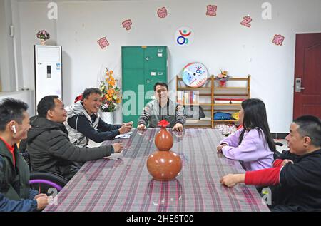 (220109) -- NANNING, 9 janvier 2022 (Xinhua) -- Tan Jianyong (3rd, R) s'entretient avec ses amis dans un centre de rassemblement pour personnes handicapées à Nanning, dans la région autonome de Guangxi Zhuang, dans le sud de la Chine, 6 janvier 2022.Tan Jianyong est un policier de 49 ans à Nanning.En 1998, trois ans après qu'il est devenu policier, Tan a été abattu dans la poitrine par un homme armé et s'est paralysé de la poitrine.Encouragé par sa famille, ses collègues et ses amis, Tan a été sorti de la mire de la dépression.Il a progressivement retrouvé la capacité d'autoprise en charge et est revenu à son poste avec des politiques de soutien du travail.Intervalle f Banque D'Images