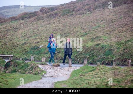 Godrevy,Cornwall,9th janvier 2022,les gens de l'hôtel pour une promenade matinale sur une journée grise, humide et lugubre à Godrevy,Cornwall.Étonnamment, quelques personnes marchaient le long des falaises pour regarder les phoques et le phare de Godrevy même si la température était un 9C froid, mais avec le facteur de vent il a été beaucoup plus froid.Credit: Keith Larby/Alay Live News Banque D'Images