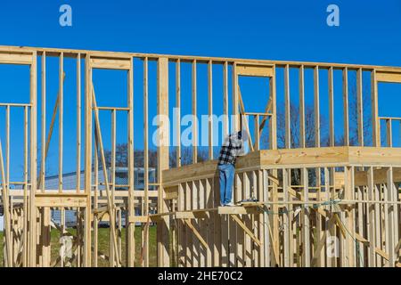 Constructeur à l'intérieur de bois homme en clouant des poutres en bois travaux de construction à l'aide d'un marteau pneumatique Banque D'Images