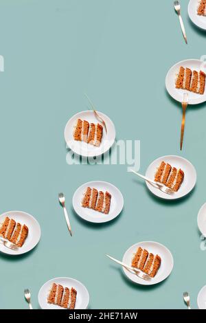 Assiette avec un morceau de gâteau de carotte sur fond vert clair dessin minimaliste brillant Banque D'Images