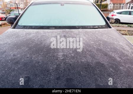 Vue avant du capot et du pare-brise d'une voiture couverts de glace givrée Banque D'Images