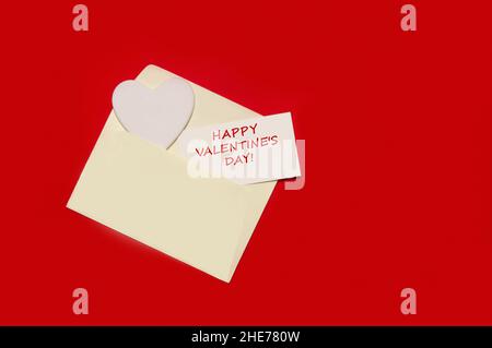 Enveloppe avec coeur et Saint Valentin félicitation sur fond de papier rouge.Maquette de carte de vœux Banque D'Images