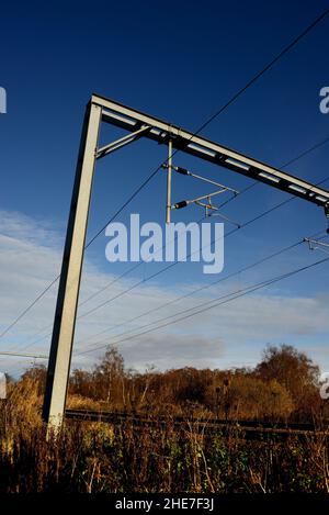 Câbles sous tension aériens le long de la ligne de chemin de fer de la côte est.(Vu d'une position sûre et légale). Banque D'Images