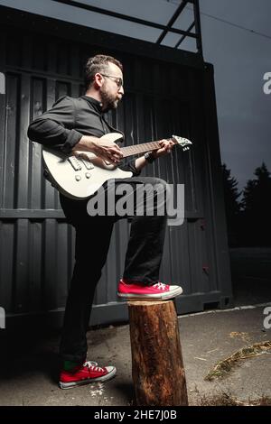 Portrait d'un guitariste mâle avec guitare électrique portant des vêtements noirs.Rock musicien concept de personnage Banque D'Images