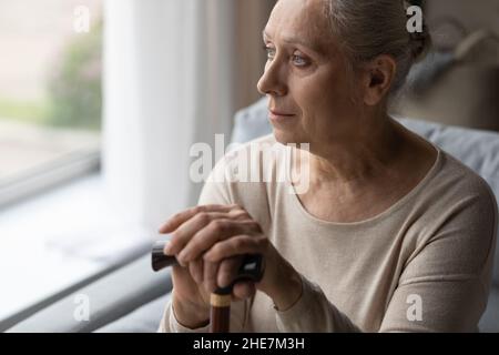 Frustrée mûre réfléchie 60s grand-mère ayant un handicap de marche. Banque D'Images