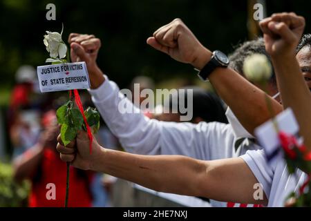 Les militants des droits de l'homme portent des signes et offrent des fleurs pour se souvenir des héros tombés lors de la commémoration de la Journée internationale des droits de l'homme de 73rd à Quezon City, dans la région métropolitaine de Manille.Le monument rend hommage aux martyrs et aux héros qui ont lutté contre la dictature de 21 ans de l'ancien président Ferdinand Marcos.Philippines. Banque D'Images