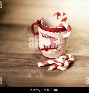 mug en laine isolante avec cerf brodé sur la table en bois Banque D'Images