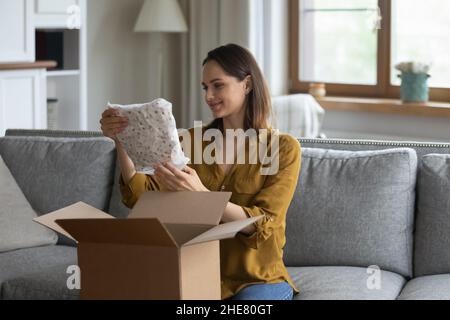 Heureuse cliente millénaire satisfaite femme recevant un achat de la boutique en ligne Banque D'Images