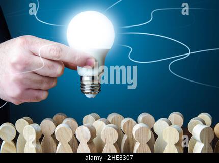 Un homme tient une ampoule idée au-dessus de la foule.Chef de projet.Travail d'équipe.Brainstorming.Créativité.Informateur.Statistiques, enquête.Recherche et devel Banque D'Images