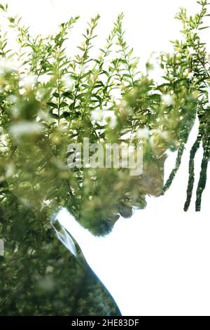 Un portrait à profil d'exposition double d'un homme combiné au feuillage. Banque D'Images