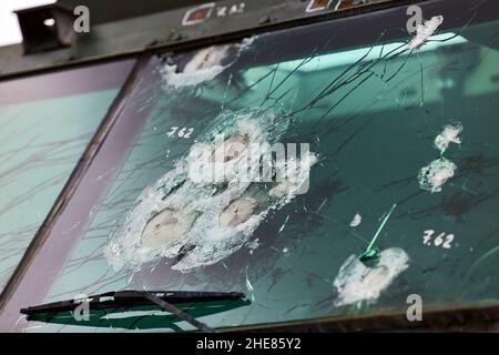 Verre blindé après un coup direct d'une arme automatique.Verre de sécurité après avoir été frappé par une balle.Voiture blindée en verre antichoc après coup de feu. Banque D'Images