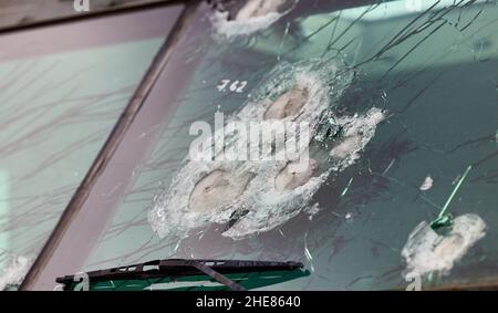 Verre blindé après un coup direct d'une arme automatique.Verre de sécurité après avoir été frappé par une balle.Voiture blindée en verre antichoc après coup de feu. Banque D'Images