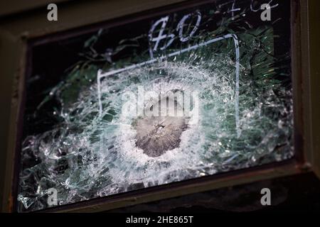 Verre blindé après un coup direct d'une arme automatique.Verre de sécurité après avoir été frappé par une balle.Voiture blindée en verre antichoc après coup de feu. Banque D'Images