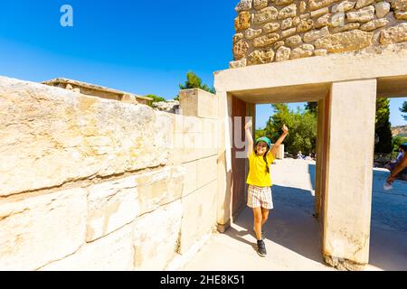 Une petite fille s'arrête pour prendre une photo d'œuvres d'art sur les murs du palais minoen à Knossos. Crète, Grèce Banque D'Images