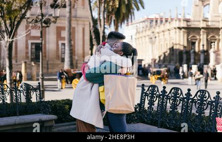 Homme et femme se tenant dans des sacs avec des cadeaux à l'extérieur Banque D'Images